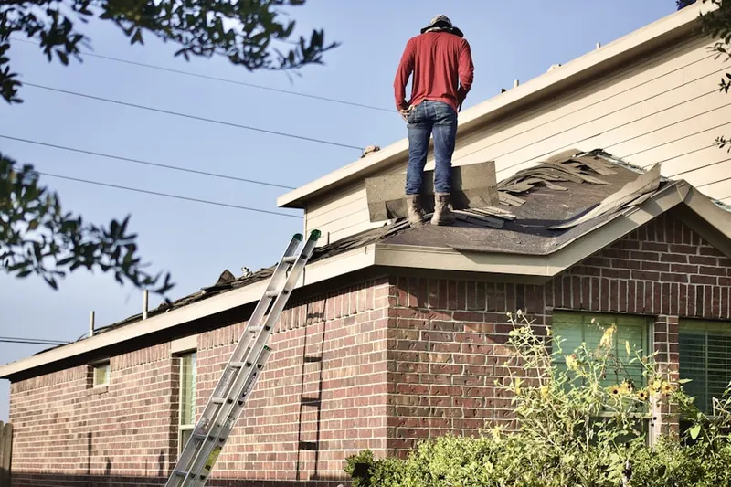 Professional roofer working on a residential roof in Harwood Estates